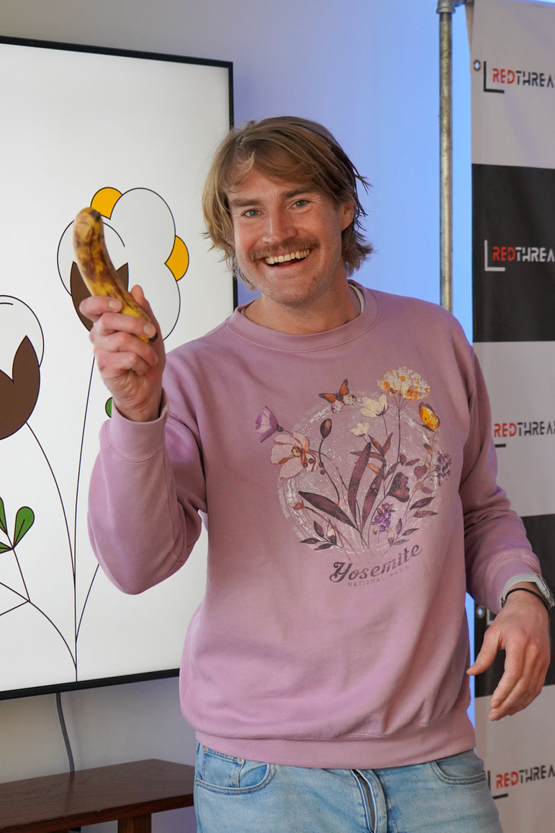 A presenter holding up a banana during a session at the RedThread X House, SXSW 2026